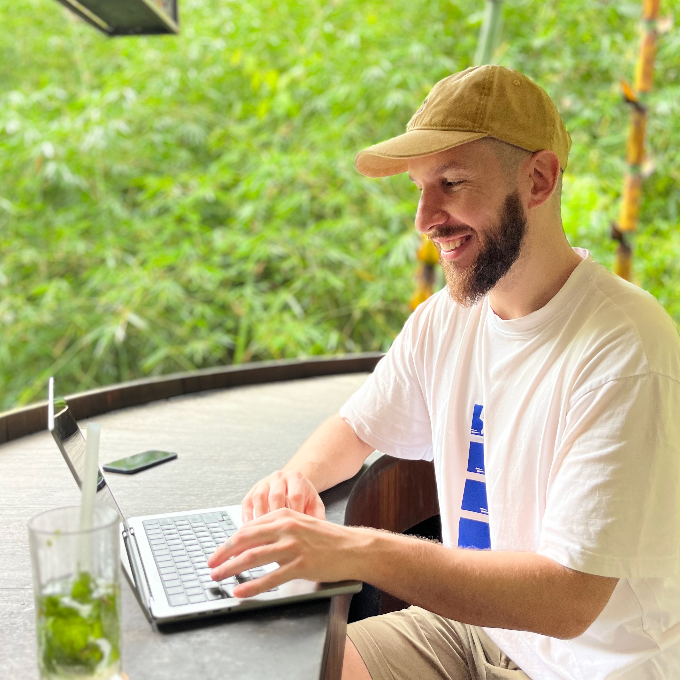 A photo of Timotej sitting outdoors, at a table with a laptop.